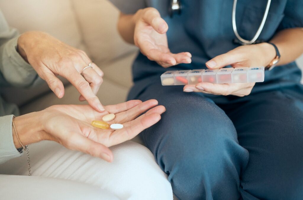 Seniorenbetreuung, Frau und Pflegekraft mit Medikamenten im Haus, Krankheitsmanagement und Gespräche über die Medikation. Pflegeheim, Krankenversicherung und Pflegekraft für die häusliche Pflege, Apotheken- und Wellness-Service